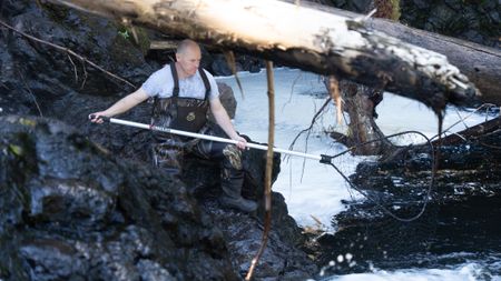 Troy Brockway fishes for salmon with a dip net. (National Geographic/Mickey Ramos)