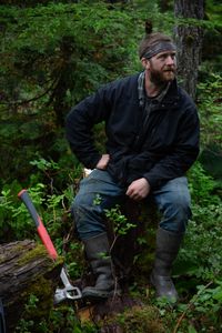 Oliver Johnson gets a lesson in logging from his experienced neighbor. (National Geographic/Lukas Taylor)