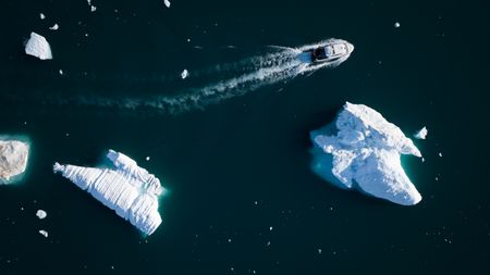 Boat travelling through icebergs. (photo credit: National Geographic/Pablo Durana)