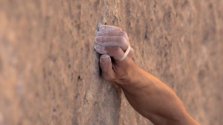 Alex Honnold grips a hold as he free solos Les Rivieres Pourpres.  (photo credit: National Geographic)