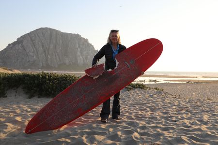 Elinor Dempsey holding up her shark-bitten surfboard. (National Geographic/Mariana Kneppers)