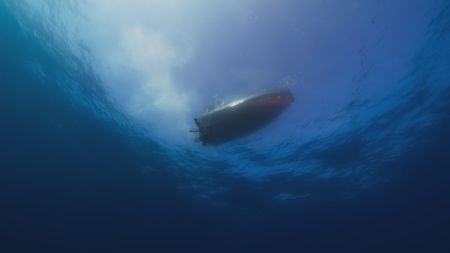 Aldo Kane and marine biologist Nathan Robinson deploy the Angler camñan ultra-sensitive, stealth camera fitted with an electronic lure that mimics the Atolla jellyfish and is used to attract predatory squid. (National Geographic)
