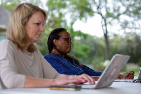 DNA Doe Project (DDP) volunteers Rebecca and Janel work the case at the DDP retreat. (National Geographic/Tom Beard)
