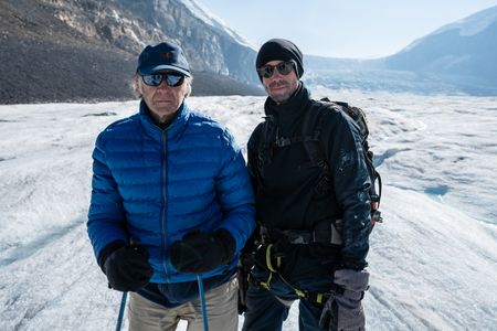 Joseph and Ranulph Fiennes stand on the Athabasca Glacier.  Sir Ranulph Fiennes, "the greatest living explorer," and his cousin, actor Joseph Fiennes, revisit Ran’s 1971 expedition of Canada’s British Columbia.