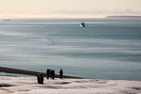 Crew Jamie Holland, PolarX guide Loup Supery, Andreas Alexander, Melissa Marquez, and PolarX guide Tom Lawton walk downhill toward the OceanXplorer. (National Geographic/Mario Tadinac)