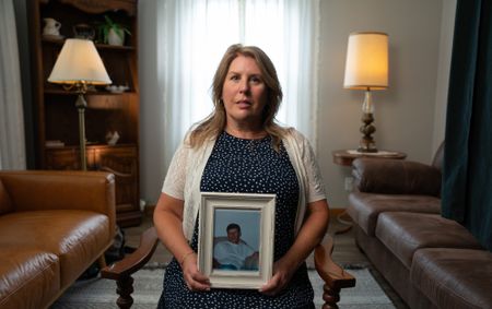 Melissa Slates, half-sister of the doe Michael Leach, holds a photo of her brother. (National Geographic/Andrew Thompson)