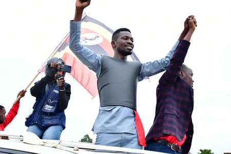 Bobi Wine and a prospective candidate running for the position of member of parliament under the National Unity Platform cheer on their supporters during one of the campaign sessions,  November 25, 2020. The campaigns have been marred by violence toward the opposition candidates and their supporters.   (photo credit: Lookman Kampala)