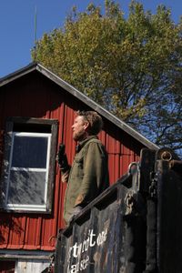 Ben Reinhold speaks into a two-way radio while standing on a truck bed at the site of the old barn. (National Geographic)