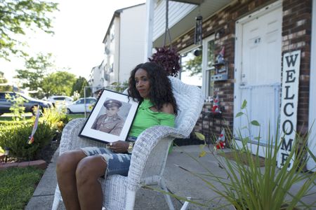 Doreen Stevens holds a photograph of her father, Johnnie Stevens, while seated outside her home in New Jersey. Staff Sergeant Johnnie Stevens was a tank commander with the 761st Black Panther Tank Battalion who served in WW2. (National Geographic/Fabian Mandujano)