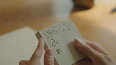 Expert in cuneiform archaeology Lara Bampfield performs ancient writing techniques. (Windfall Films)