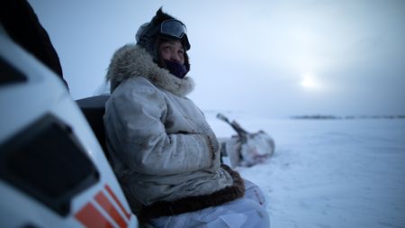 Agnes Hailstone waits for her husband, Chip Hailstone while he peruses a herd of caribou. (BBC Studios Reality Productions, LLC/Ashton Hurlburt)