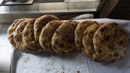 Ramadan Pide is fresh out of the oven at Master Baker Sami Eryılmaz's bakery, Tophane Tarihi Tas Firin, in Istanbul. This bread is traditionally eaten at Iftar, the breaking of the Ramadan fast. Bakers like Eryılmaz produce it at a financial loss in an effort to maintain a centuries-old tradition. (National Geographic/Madeline Turrini)