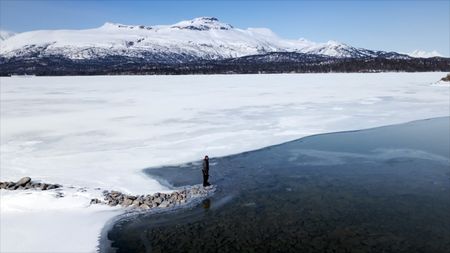 Joel Jacko looking over a glass frozen lake. (National Geographic)