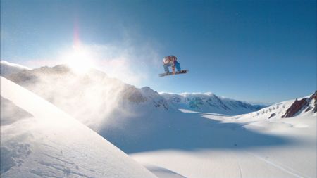 Travis Rice jumps as he snowboards on a mountain in Alaska.  (photo credit: Red Bull Media House)