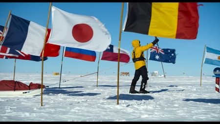 Will Smith skis past flags surrounding the South Pole on his grueling trek to the southern most point of the earth. (credit: National Geographic)