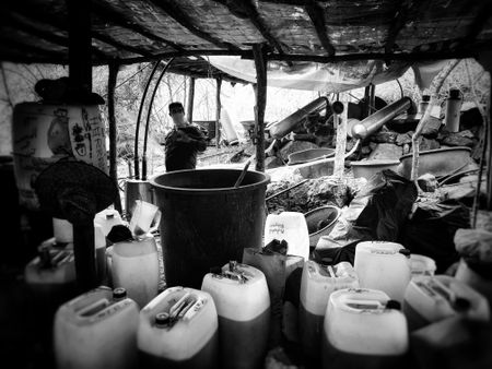 Sinaloa meth lab tent complex barrels with a guard nearby. (Nick Quested)