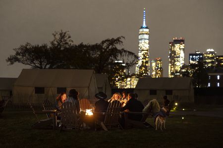 Antoni Porowski makes s'mores around a campfire with other visitors of Collective Retreats on Governor's Island. (National Geographic/Jose Alvarado Jr.)