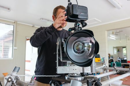 Camera assistant, Woody Spark, setting up the specialist underwater camera system that will be used to film Day octopus (Octopus cyanea) on the Great Barrier Reef.  (photo credit: National Geographic/Harriet Spark)