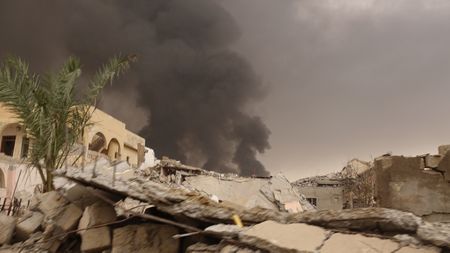 QAYARRAH, IRAQ - Black smoke rises up from the oil fires set by ISIS in Qayarrah village after their departure. (photo credit: Junger Quested Films LLC/Nick Quested)