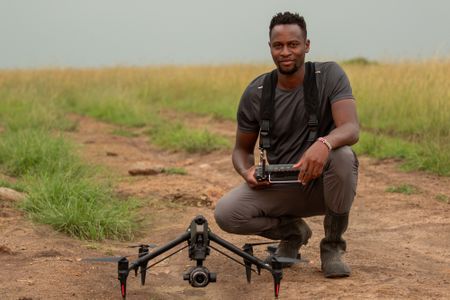 Anthony Njuguna prepares to capture footage of Summer's Pride via drone. (National Geographic/Joe Treddenick)
