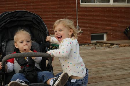 Silas Pol sucks on his thumb in his baby carriage while his sister, Abigail Pol, grabs onto the baby carriage. (National Geographic)