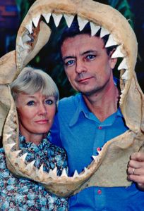 Ron & Valerie Taylor framed by a shark jaw skeleton. (photo credit: Ron & Valerie Taylor)