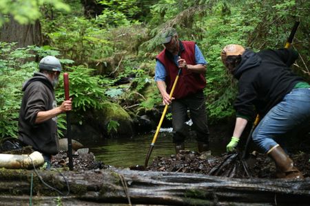 Dave Palmer, Jiggy Nichols and Veronica Arrants rebuild a dam in their community. (National Geographic/Wayne Moss)