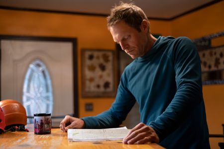 Professional kayaker Ben Stookesberry studies the map of a river on a desktop.  (National Geographic/Harrison Gayton)
