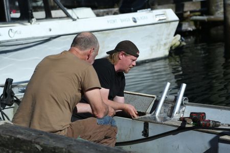 Sam Carlson and David Squibb install a newly constructed fairlead on Squibb's skiff. (National Geographic/Wayne Moss)