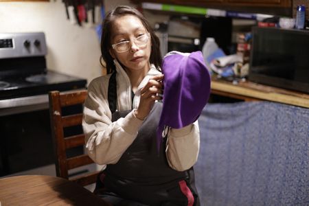 Louise Moses sews a hat for one of her children. (National Geographic/Wayne Shockey)