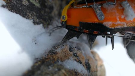 The snow shoes of a professional climber step on a hold as they ascend a mountain.  (credit: Jimmy Chin Productions)
