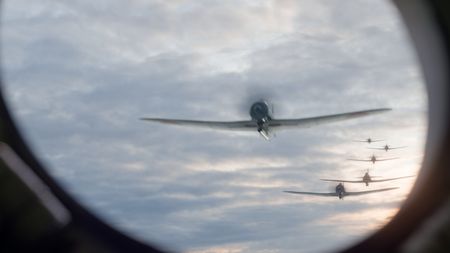 Japanese planes are seen through a USS West Virginia's window in a WW2 historic reenactment scene for "Erased: WW2's Heroes of Color. The series tells the stories of three Black heroes who miraculously survived the attack on Pearl Harbor. (National Geographic)