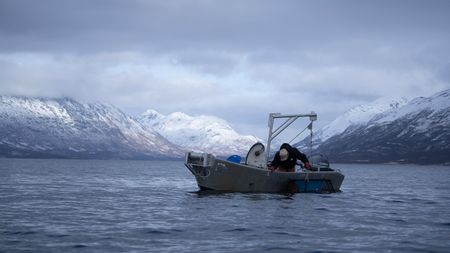 Marvin Agnot sets crab pots in the water. (National Geographic/Ashton Hurlburt)