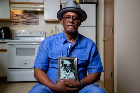 Chiam Bismillah Senior, father of the doe, holds a picture of his son, Kaif (birth name Keith Lavell Bibbs). (National Geographic/Tom Beard)