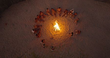 Will and The San sit around a camp fire in Botswana. (credit: National Geographic)