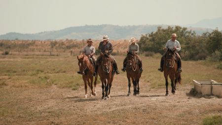 Contributors Stefano Pavin, Luca Bettiol, Luca De Santis, and Sara Nuti ride their horses across the Alberese farm in Tuscany, whips in hand.  (credit: National Geographic)