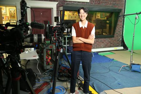 A-Bel Gong standing with arms crossed next to video equipment. (National Geographic/Robert Toth)