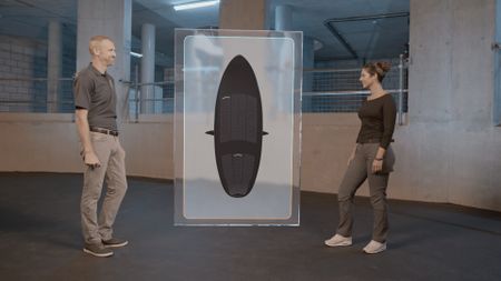 Dr. Mike Heithaus speaking with Dr. Diva Amon while standing next to a GFX boat on the 'coral' information board while in the shark lab studio. (National Geographic)