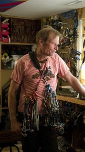 Conrad Anker stands in his gear room holding climbing equipment as the film crew sets up the next shot.   (National Geographic/Elena Gaby)