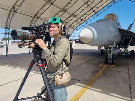 DOP Jon Southgate-Sayers films in front of an F-18.  (Credit: National Geographic/Evan Parker)