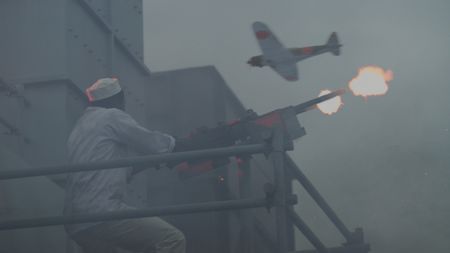 Mess attendant Doris Miller (played by Abdul Sulaiman) shoots at Japanese planes in a WW2 historic reenactment scene for "Erased: WW2's Heroes of Color. The series tells the stories of three Black heroes who miraculously survived the attack on Pearl Harbor. One of these men, mess attendant Doris Miller, defied racial stereotypes when he shot down enemy planes during the attack. (National Geographic)