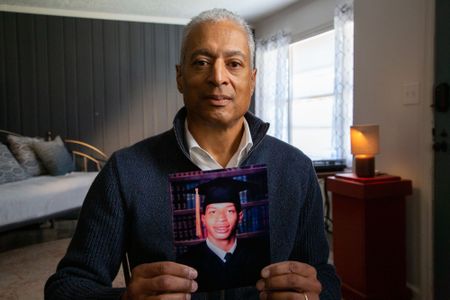Brett Gaines, a DNA relative of Fulton County John Doe David Brown, holding David's graduation picture. (National Geographic/Tom Beard)