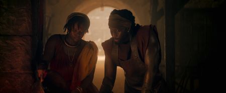 Aurelia Masuri, played by Angelina Chudi, and her husband Marcus Masurius, played by Theo Ogundipe, work together at the forge, leaning over the fire. (National Geographic)