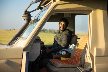 Wildlife guide, Bazili Kessy sits in the drivers seat of his Jeep. (credit: National Geographic/Jigar Ganatra)