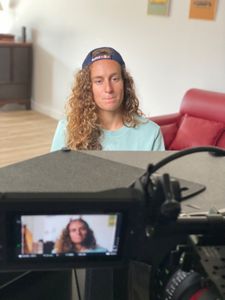 In front of cameras, big wave surfer Justine Dupont is being interviewed.  (National Geographic/Gene Gallerano)