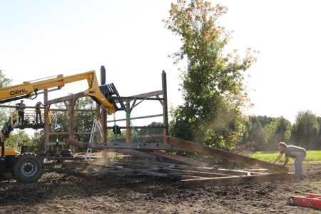 Scott Brady, Seth Doble, Bill Klein, and Charles Pol continue to take down and stack lumber from the old barn to transport it all to the Pol family's farm. (National Geographic)
