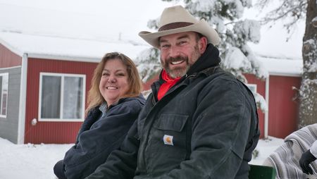Vet clinic receptionist Julie Hochstein and Dr. Ben Schroeder smile in the front seat of a sleigh. (National Geographic)
