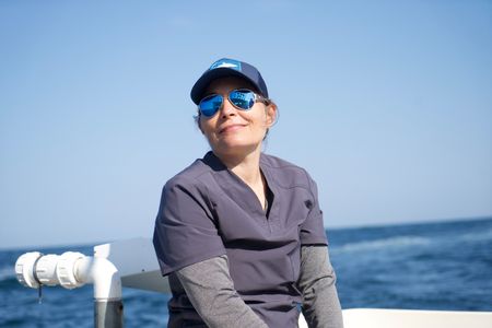 Dr. Alisa “Harley” Newton sits on the back of the boat, eagerly awaiting their first catch. (National Geographic/Brandon Sargeant)
