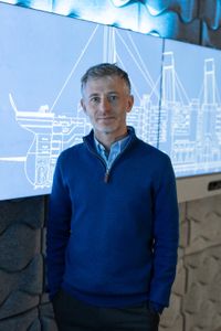 Simon Benson poses in front of blueprints of the Titanic. (National Geographic/Gary Moyes)