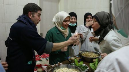 Al Ghouta, Syria - Dr Salim (L) holds a light for Amani (R) to blow out during her birthday celebration in the hospital. (National Geographic)